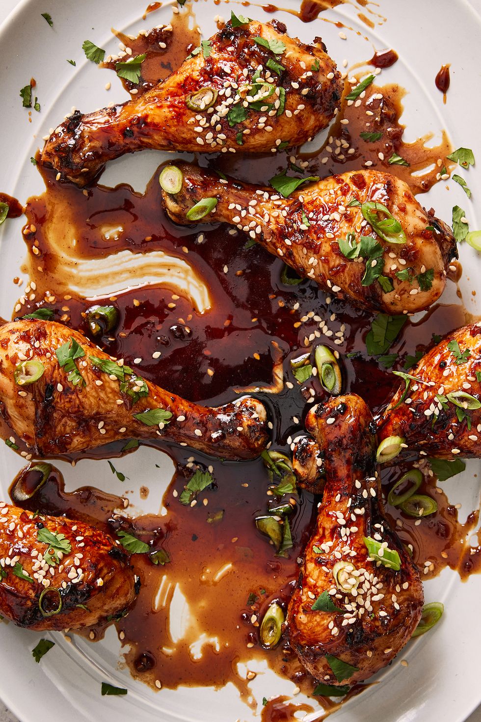 air fryer drumsticks coated in a soy, coca cola sauce topped with sesame seeds