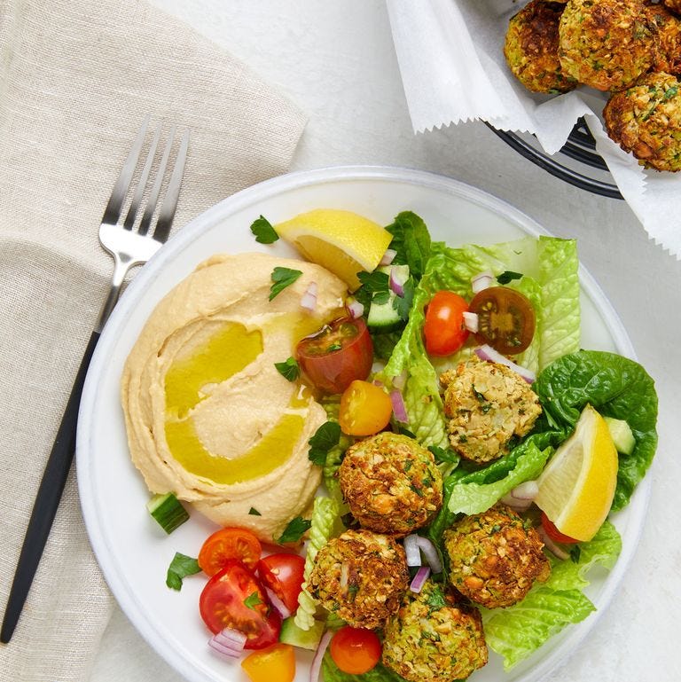 air fryer falafel over a salad on a plate with hummus