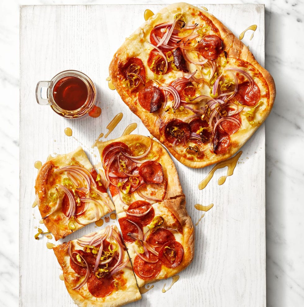 pepperoni pizzas with red onions on top