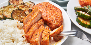air fryer pork chops on a plate with white rice and roasted zucchini air fryer pork chops on a plate with white rice and roasted zucchini