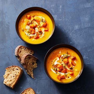 a bowl of butternut squash fall soup with slices of bread on the side