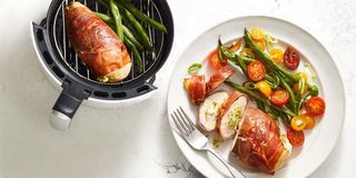 air fryer stuffed chicken wrapped in prosciutto on a white plate