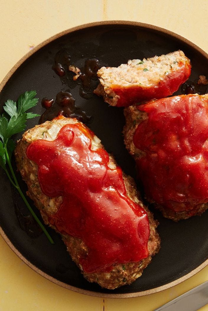 air fryer turkey meatloaf topped with lots of ketchup on a black plate