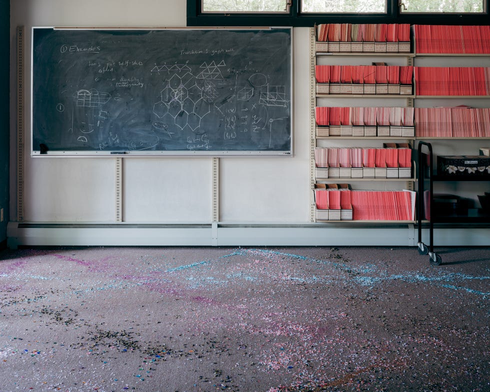 floor with glitter spread all over it under a whiteboard with science problems scrawled on it