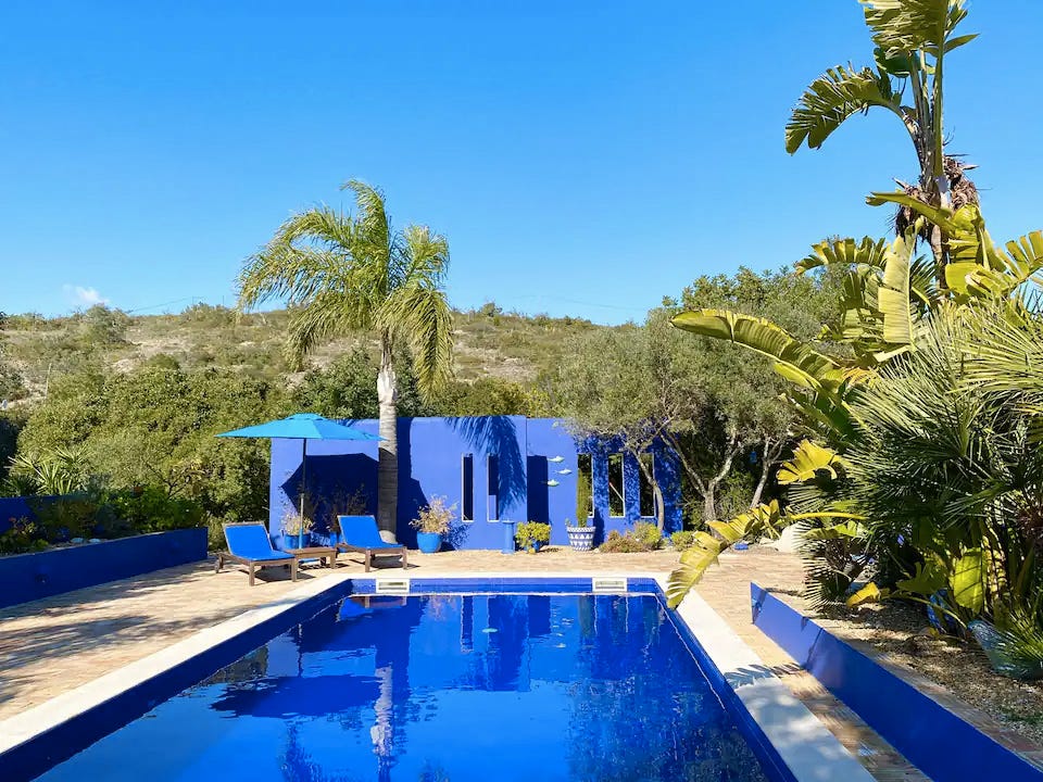 a swimming pool with palm trees and a building in the background