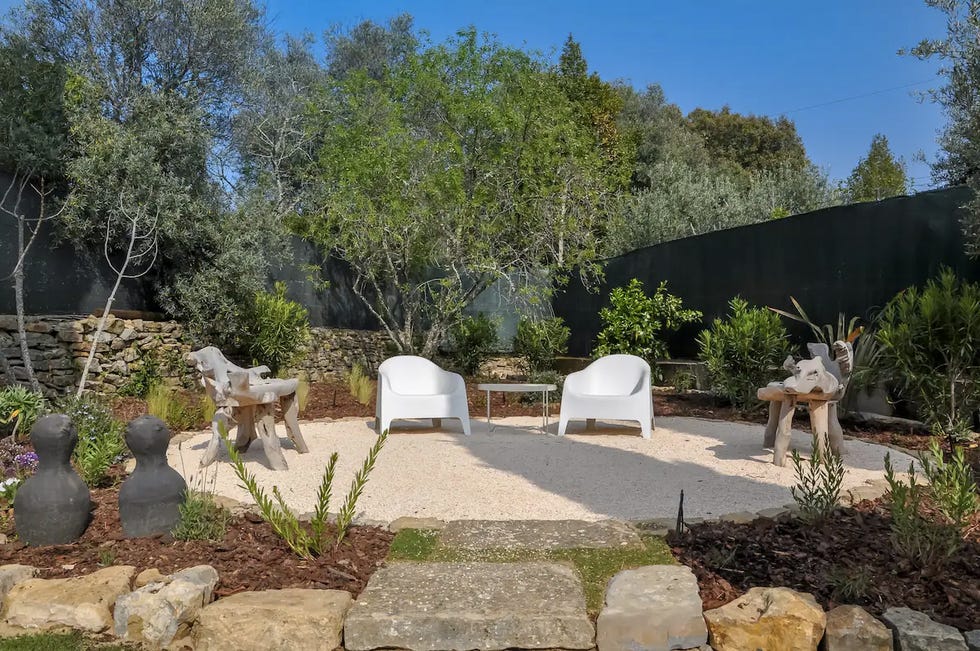 a garden with chairs and trees