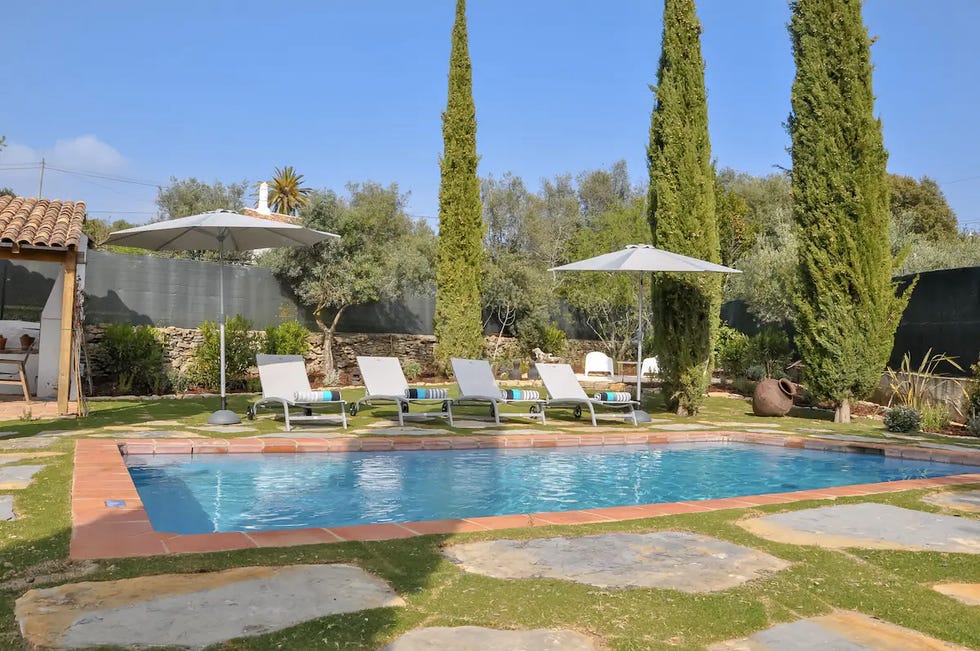 a pool with chairs and umbrellas