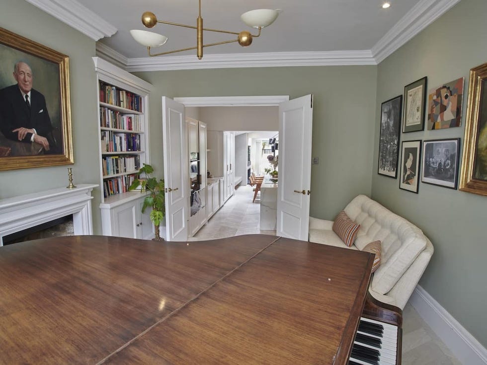 a room with a wood floor and a wood floor with a bookcase and a fireplace