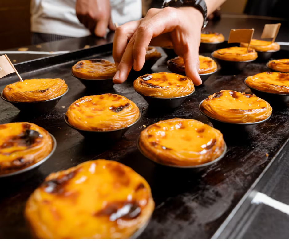 custard tarts being handled and prepared in a baking environment