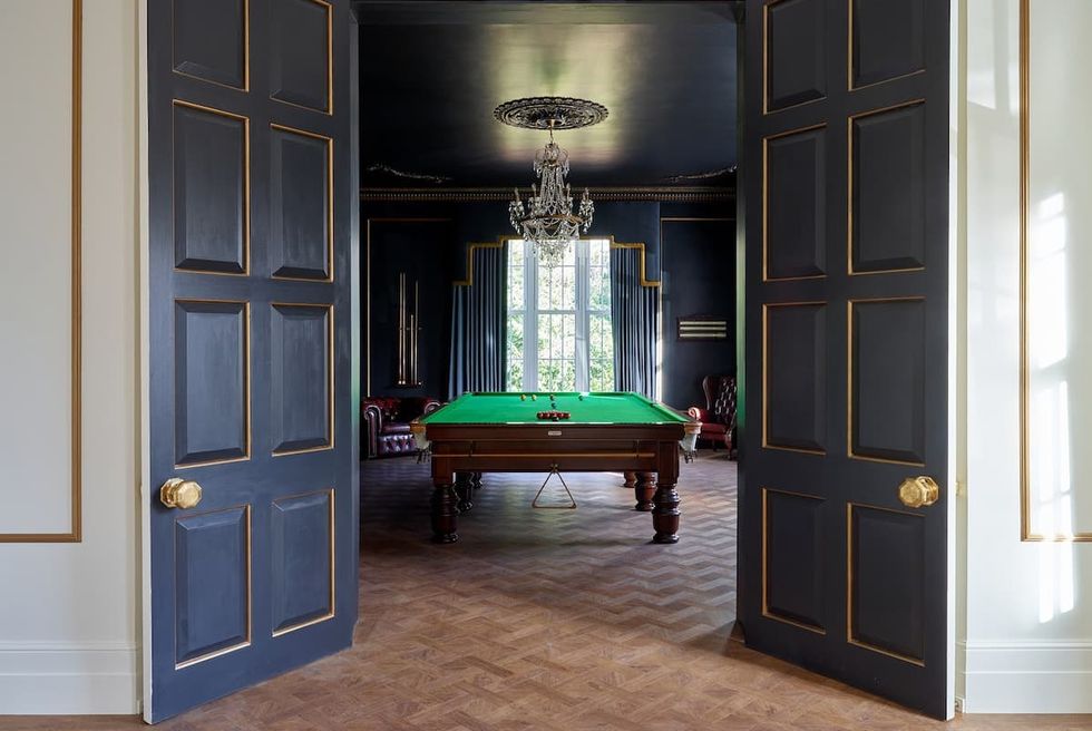a room with a pool table and a chandelier