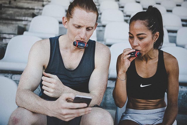 dos atletas entrenando la respiración con un inhalador