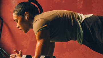 a woman doing a plank wearing a pair of earbuds