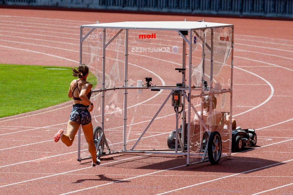 woman running behind airshield on a track