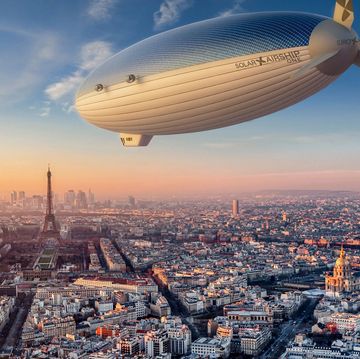 a large blimp flying over a city