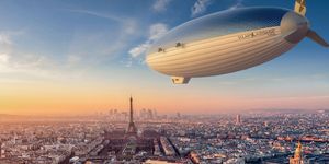 a large blimp flying over a city