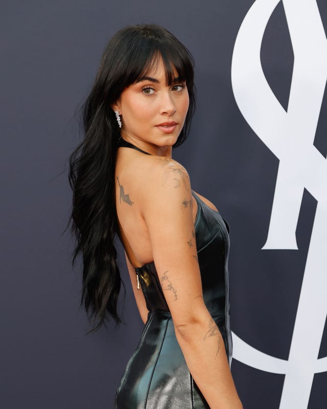 aitana posando con vestido negro ajustado en el photocall de una fiesta de yves saint laurent