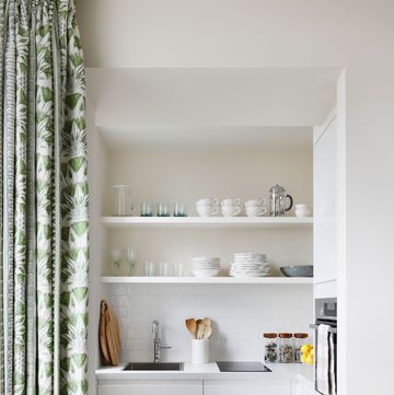 a small white kitchen behind a curtain