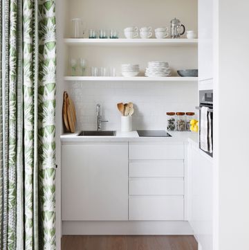 a small white kitchen behind a curtain