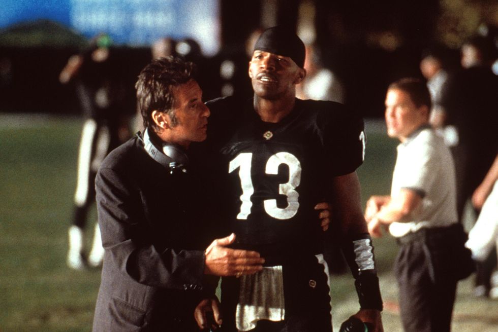 a photo from the film any given sunday, with al pacino speaking to jamie foxx on a football field, with foxx wearing a football uniform