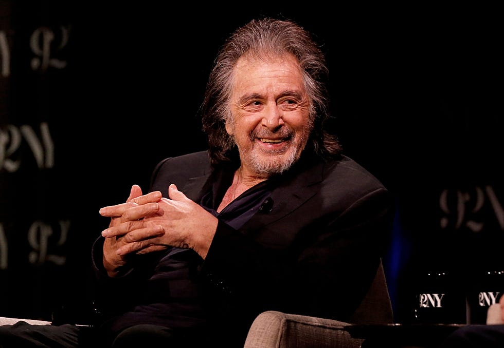 al pacino looking to his left and smiling as he speaks to a panel reporter