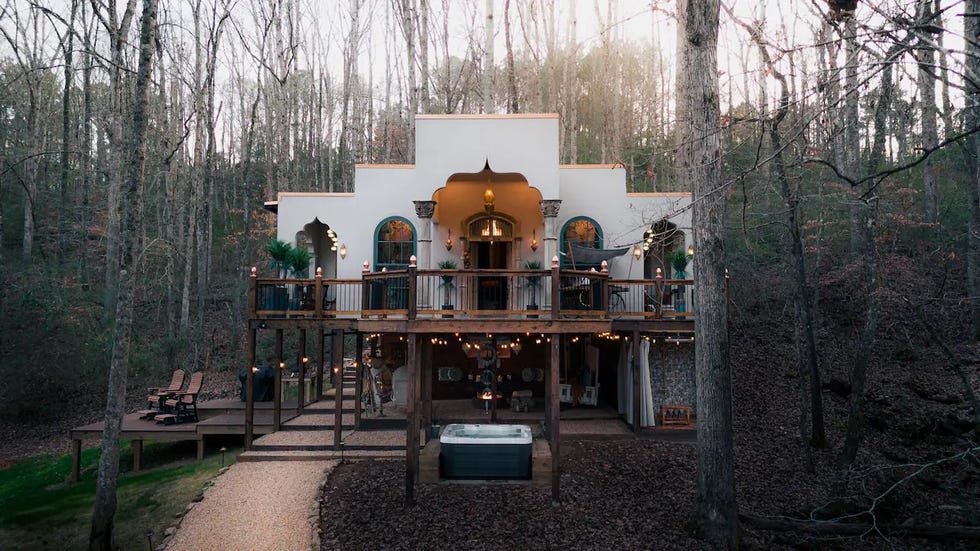 a house with a deck and trees around it