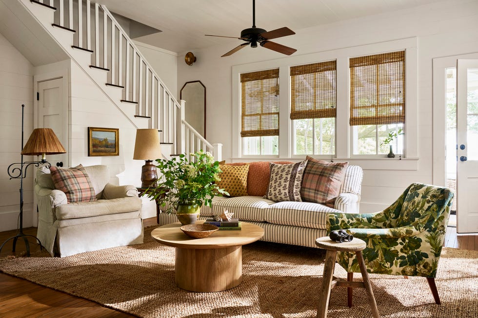 family room with creamy white walls, ticking stripe sofa, and green botanical print chair