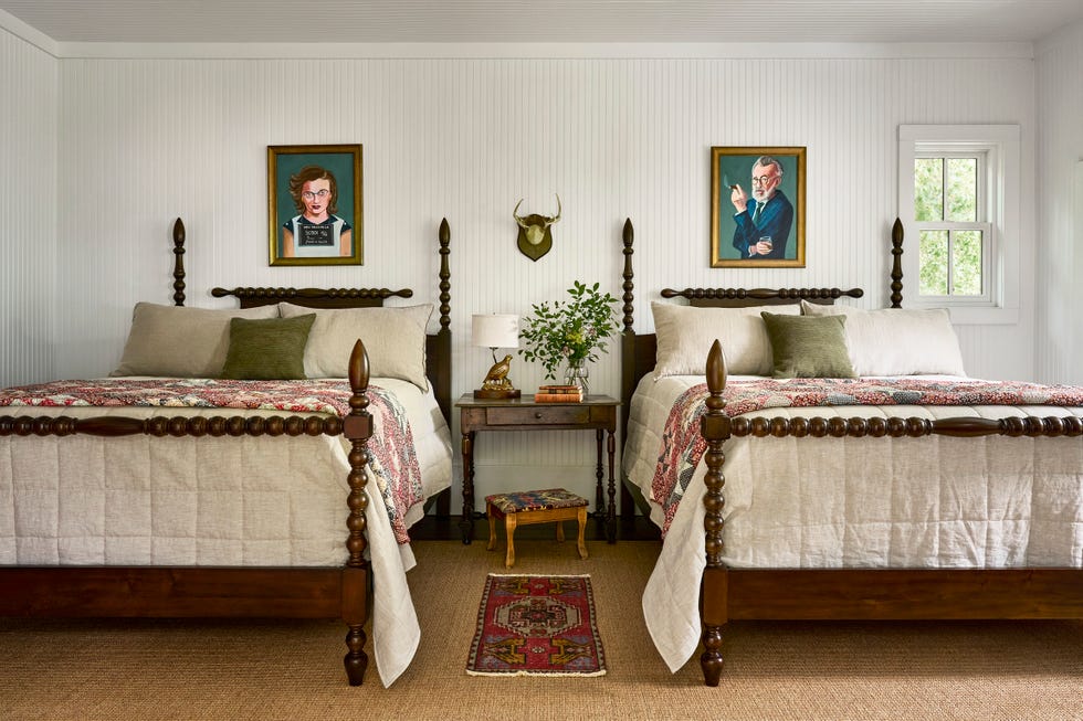 guest bedroom with two beds and portraits above them