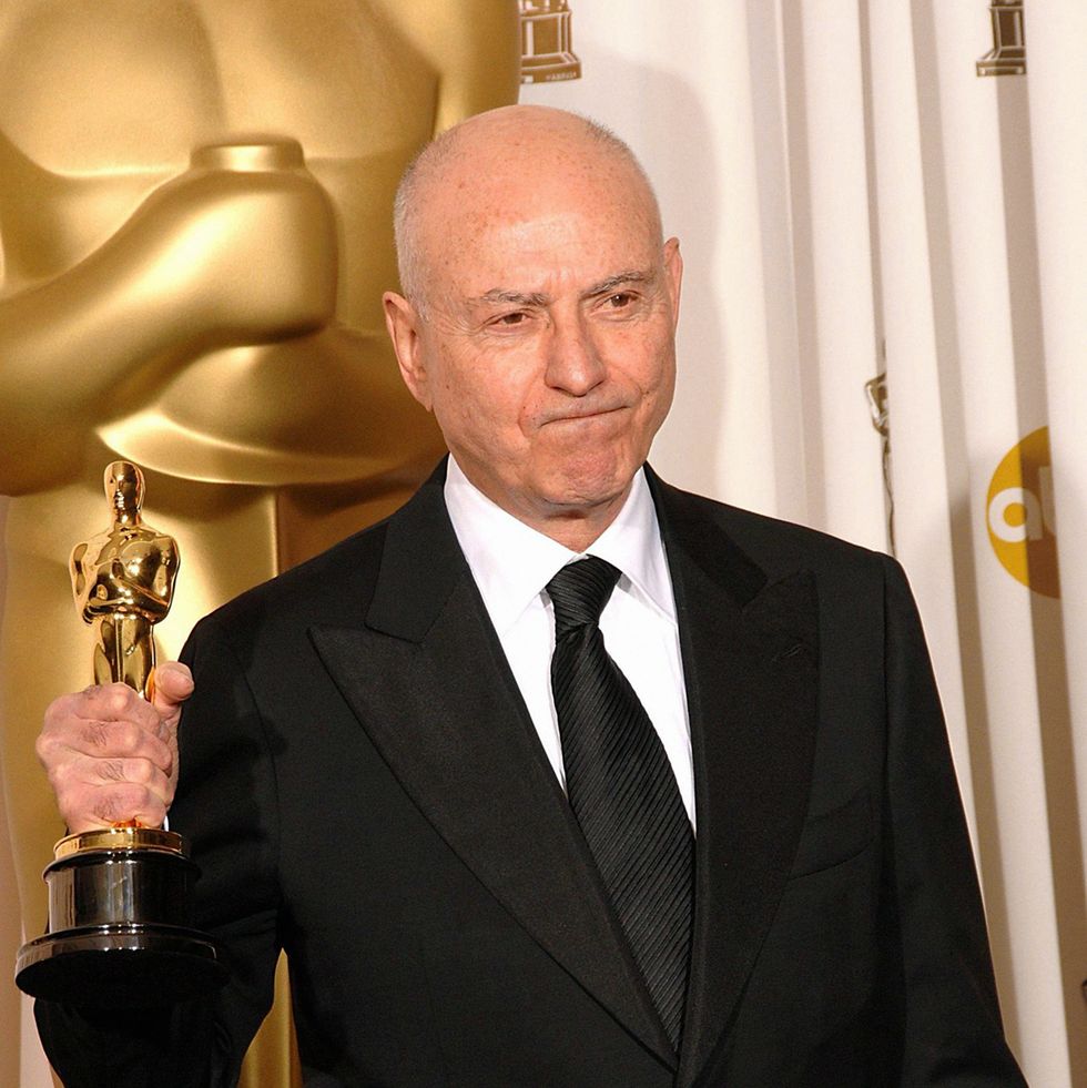 alan arkin wearing a black suit and holding an oscar