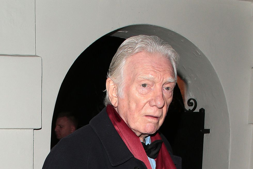 alan ford attending an event in february 2023, wearing a black coat and red scarf