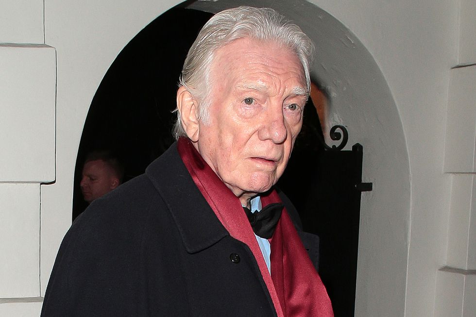 alan ford attending an event in february 2023, wearing a black coat and red scarf