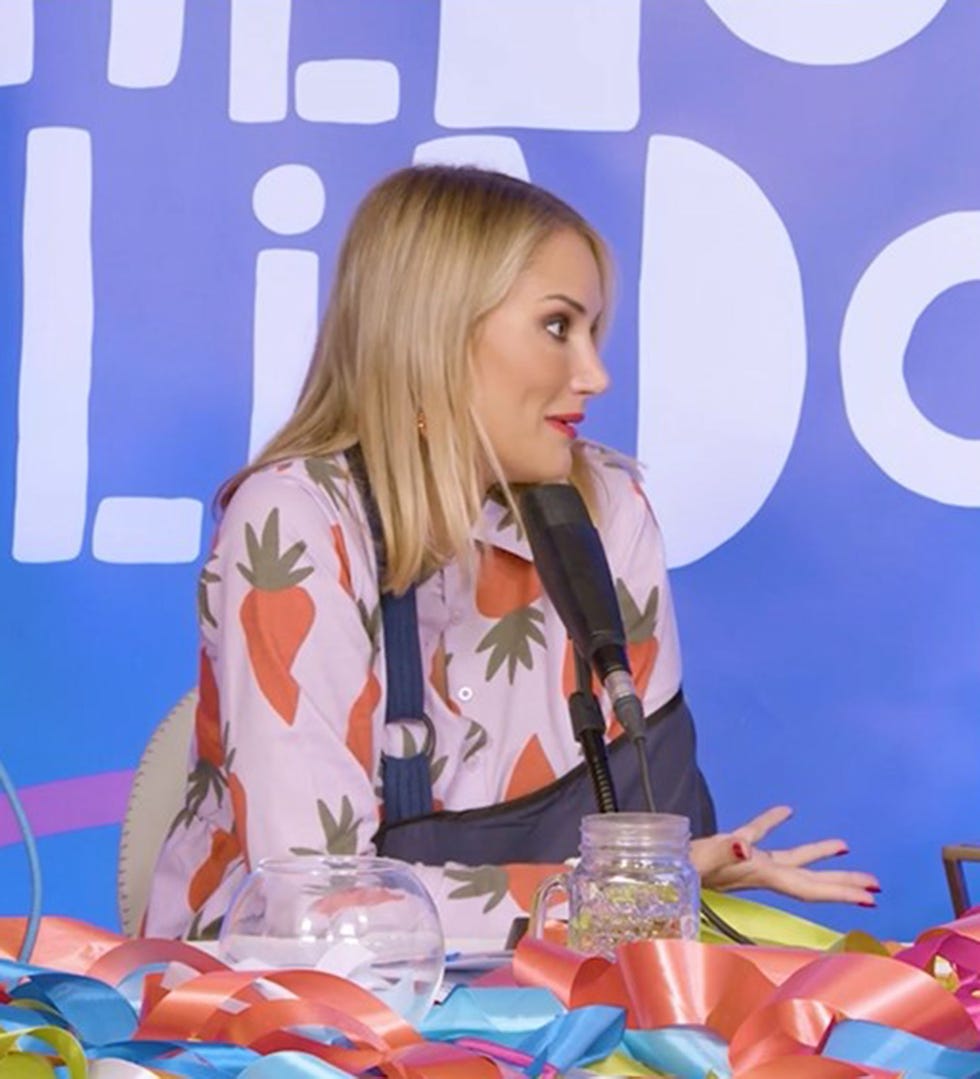la colaboradora con el brazo en cabestrillo y camisa rosa con estampados