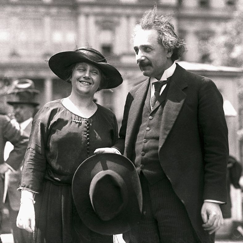 albert einstein holding his hat next to his wife elsa
