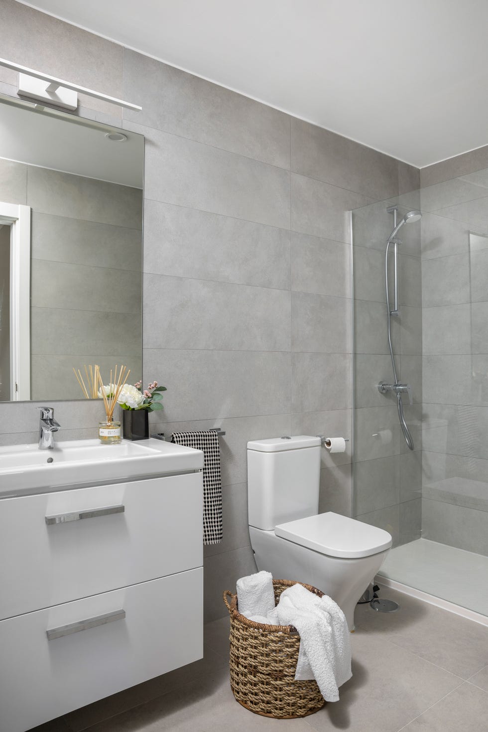 baño con ducha y mueble blanco volado