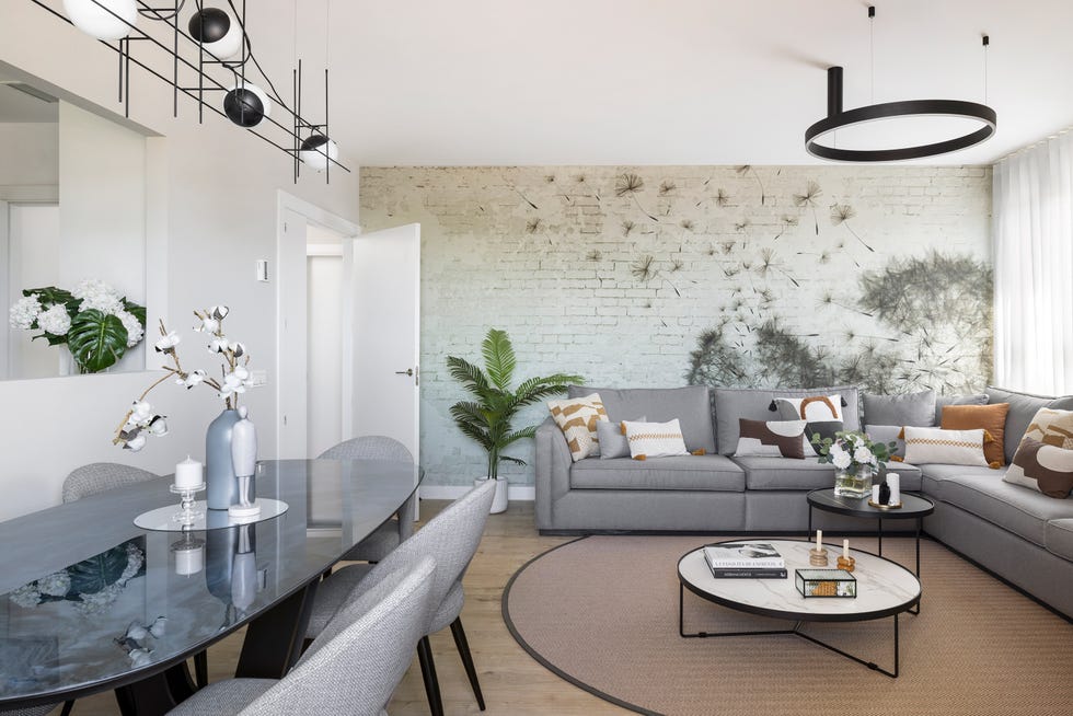salón comedor con sofá rinconera gris y papel pintado en una pared