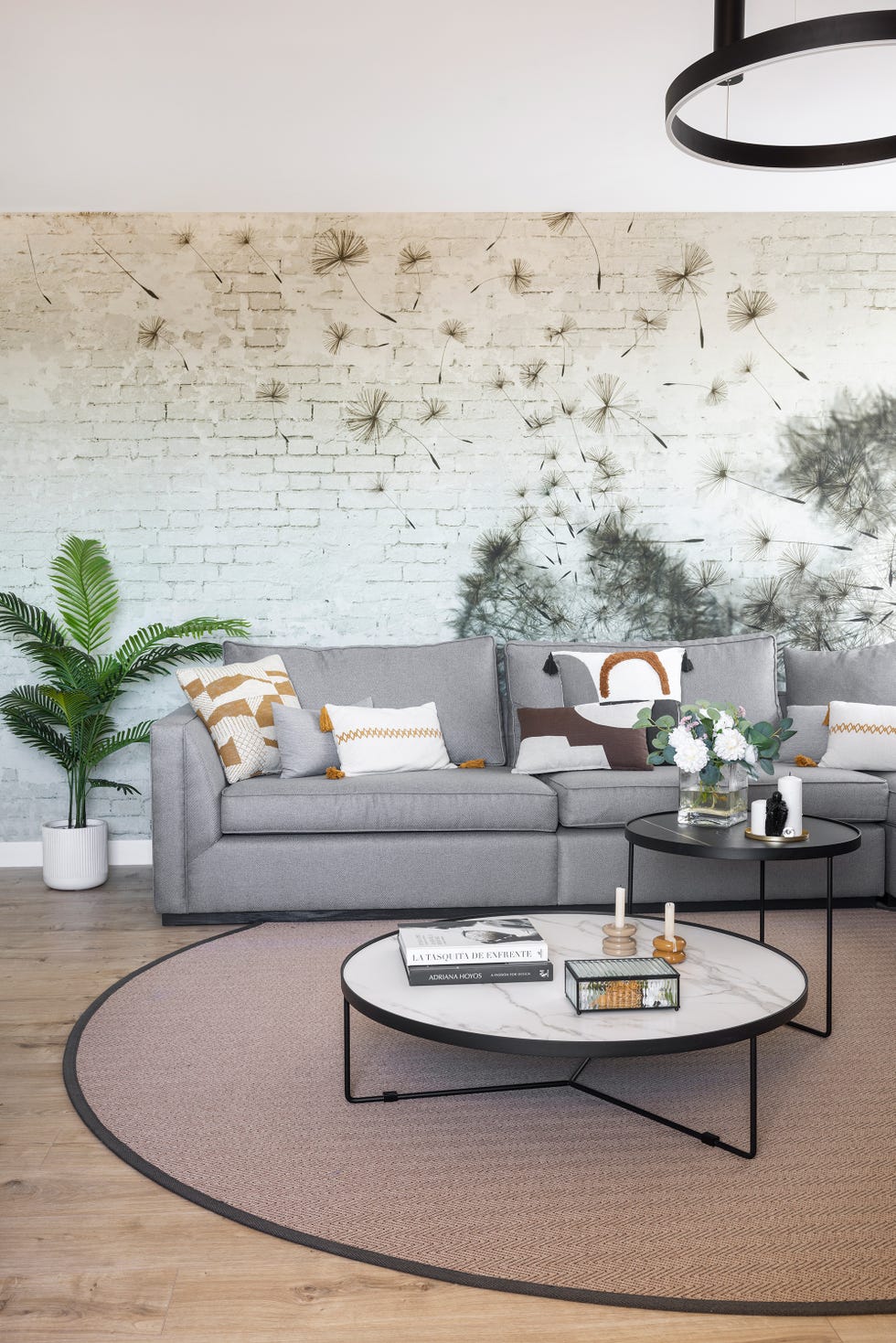 salón con sofá gris, mesas nido y papel pintado en una pared