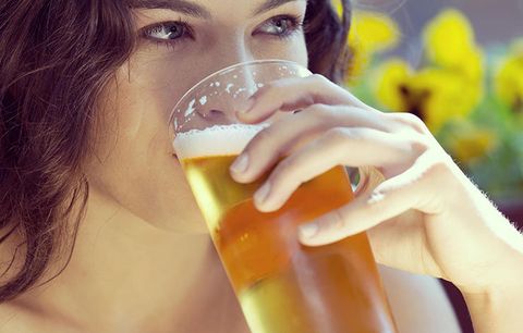 A woman drinking a beer. 