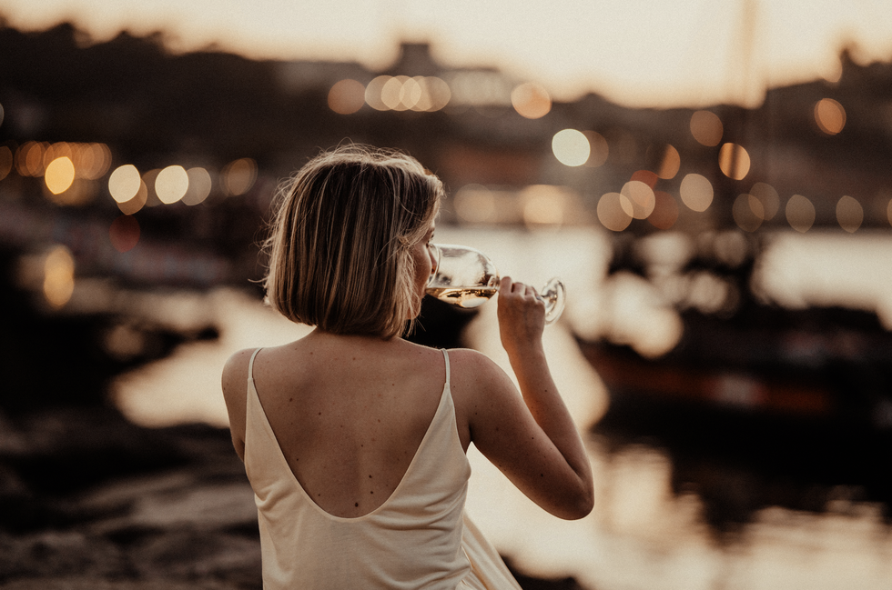 woman drinking wine alone on a harbour