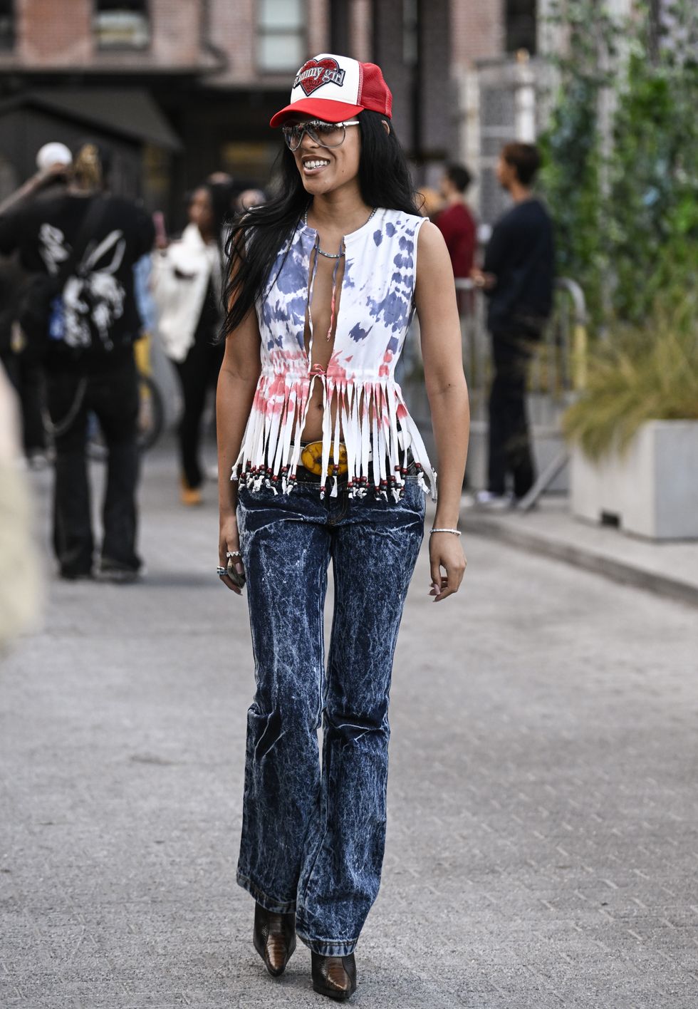 Street Style photo of Aleali May who wears a red trucker cap during New York Fashion Week