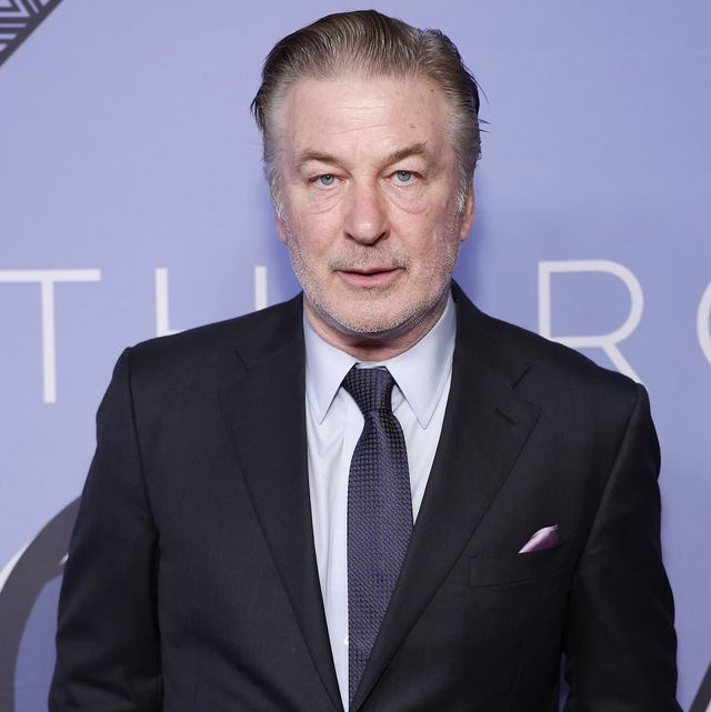 alec baldwin wearing a suit jacket and tie posing for a photograph