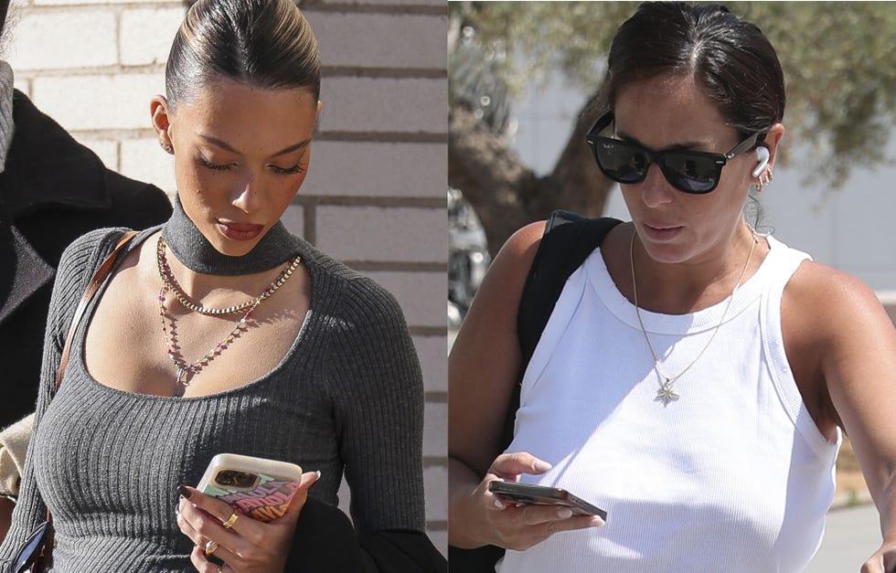 two women outdoors both holding mobile phones