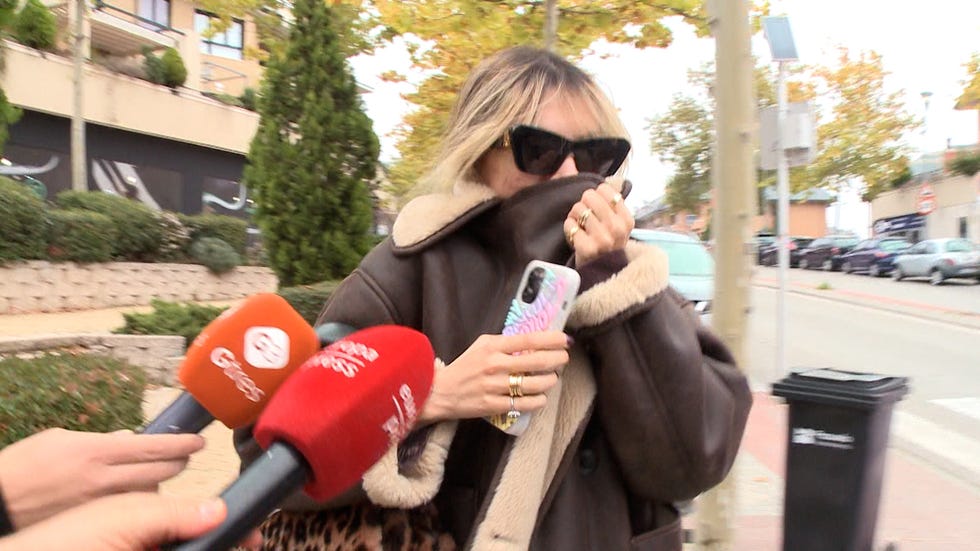 individual speaking on the phone while being approached by news reporters