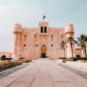 a stone building with a flag on top with lahore fort in the background a stone building with a flag on top with lahore fort in the background