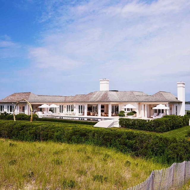 white house on the ocean with green surrounding it