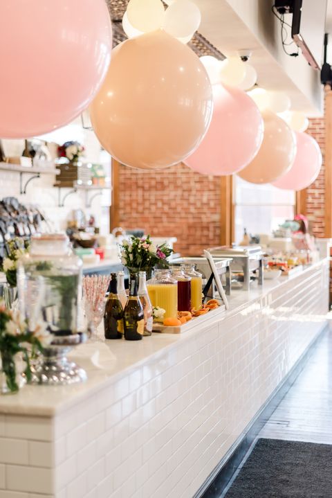 food is displayed next to a mimosa bar at alex drummond's wedding shower