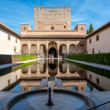 het alhambra fort in granada met een weerspiegelende fontein om de voorgrond
