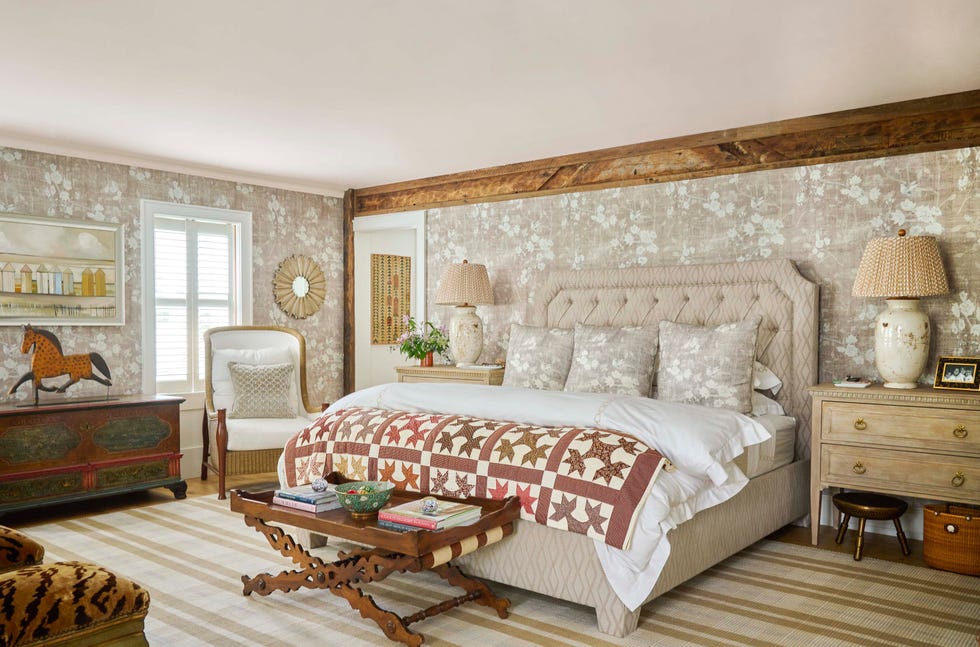 primary bedroom with bed with upholstered headboard, striped rug, and floral wallpaper