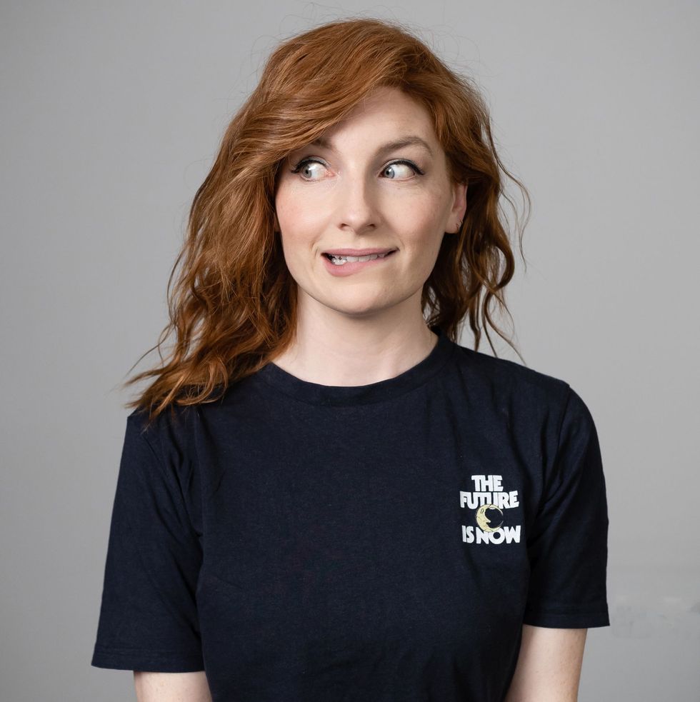 alice levine in a black t shirt against a grey background