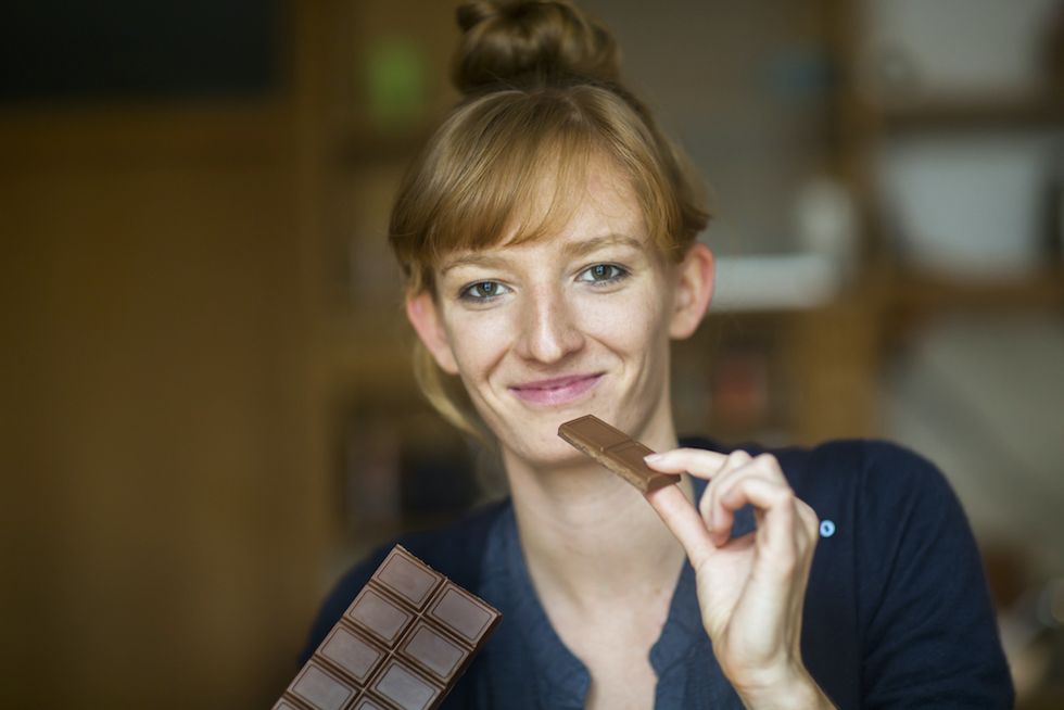 retrato de una mujer con una tableta de chocolate en la mano