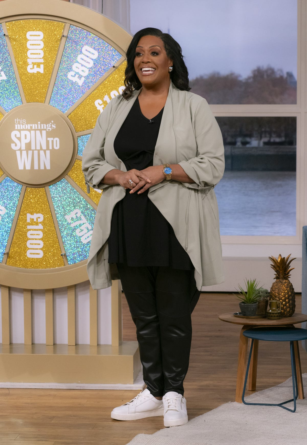 alison hammond on the set of this morning wearing black trousers and a top with a sage waterfall duster jacket