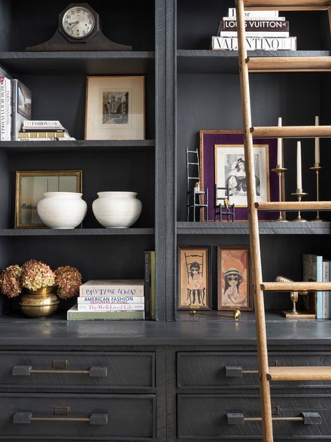 dark gray bookcase with objects and ladder